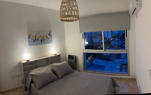 ラプラタにあるDepartamento moderno y luminoso en LA PLATAのベッドと大きな窓のある寝室