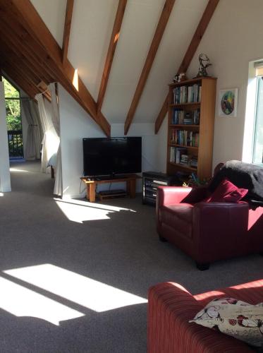 a living room with a couch and a flat screen tv at Sweet Retreat in Mangawhai
