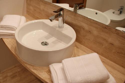 a bathroom with a white sink and a mirror at Aparthotel Golf Beach in Pals