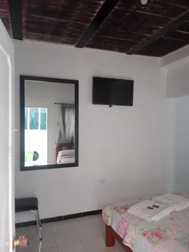 a bedroom with a mirror and a bed and a chair at D apartaestudio amoblado central con cocina y baño in Chiquinquirá