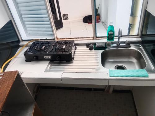 a kitchen counter with a stove and a sink at D apartaestudio amoblado central con cocina y baño in Chiquinquirá