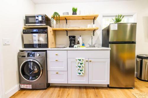 a kitchen with a refrigerator and a washer and dryer at CozyHome BigGrdn RmWTub PetOkUCF in Orlando