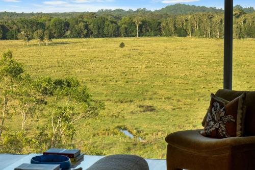 a living room with a couch and a view of a field at Myocum Ridge Farm in Myocum