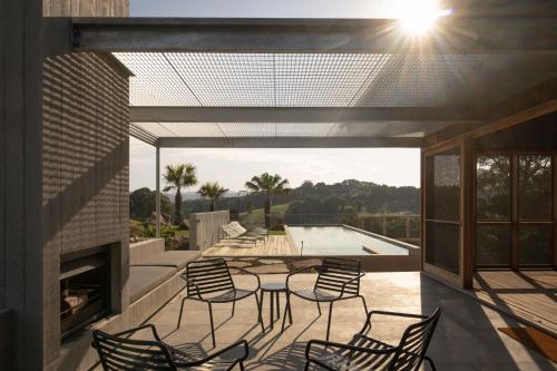 a patio with chairs and a table and a pool at Myocum Ridge Farm in Myocum