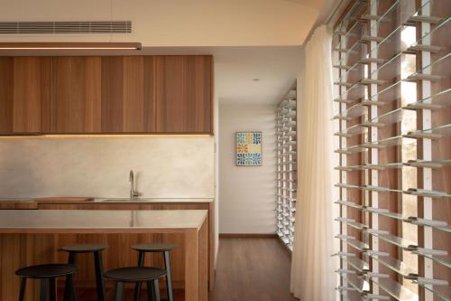 a kitchen with stools and a counter with a sink at Myocum Ridge Farm in Myocum