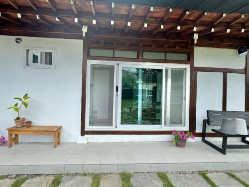 a patio with a bench and a wooden roof at Hongcheon Hanok Stay Scenery in Hongcheon