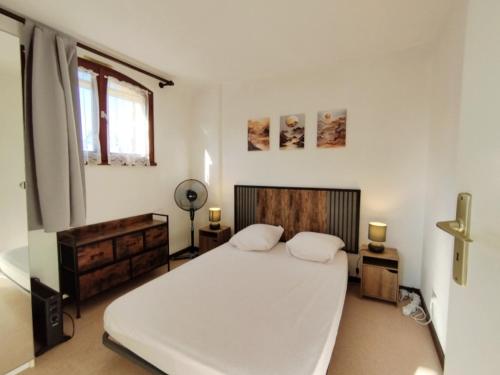 une chambre blanche avec un lit et une fenêtre dans l'établissement Confortable T2 avec parking privatif et loggia - 4 personnes - FR-1-795-24, à Fleury