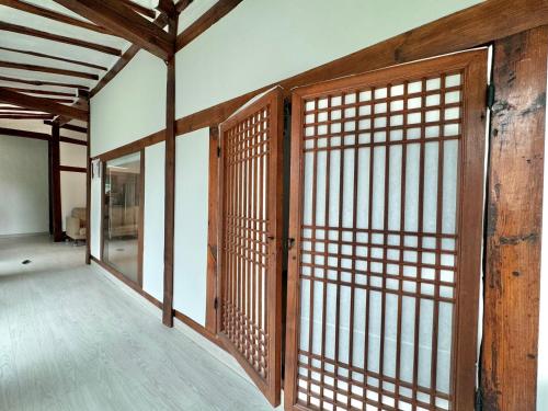 an empty room with a wooden door andwindows at Hongcheon Hanok Stay Scenery in Hongcheon