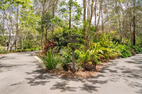 a sign in the middle of a road with plants at Bush N Beach Sunshine Coast near Eumundi & Noosa in Doonan