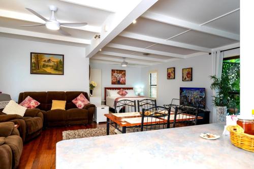 a living room with couches and a table at Bush N Beach Sunshine Coast near Eumundi & Noosa in Doonan