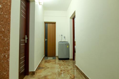 a hallway with a refrigerator in a room at MAS Residency in Ernakulam