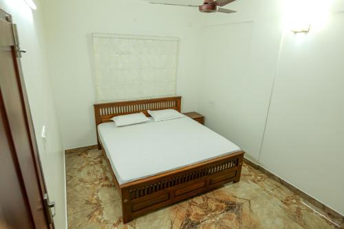 a small bedroom with a bed in a room at MAS Residency in Ernakulam