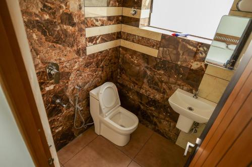 a bathroom with a toilet and a sink at MAS Residency in Ernakulam