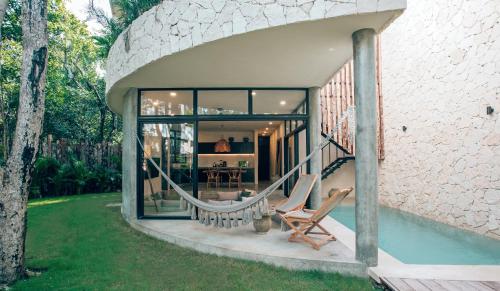 a house with a pool and two chairs in a yard at Luxury Jungle Villa-Pvt Pool -100mbs- Concierge 8A in Tulum