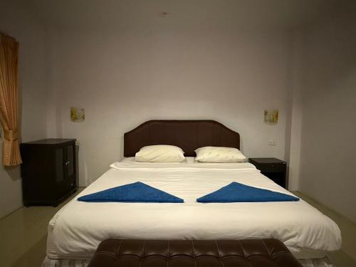 a bed with two blue pillows on it at Sawasdee House in Lamai