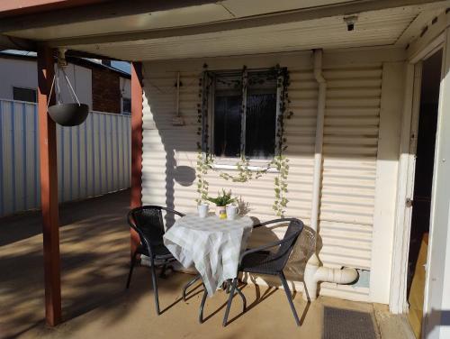 a table and chairs on the back porch of a house at Corella Accommodation 1A in Boulder