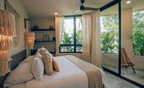 a bedroom with a bed and a large window at Luxury Jungle Villa-Pvt Pool -100mbs- Concierge 8A in Tulum