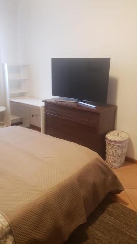 a bedroom with a bed and a flat screen tv at Our real happy place in Cavallino-Treporti