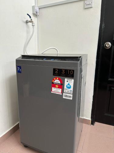 a small refrigerator with stickers on it next to a door at Rafeeqs Homestay in Teluk Intan