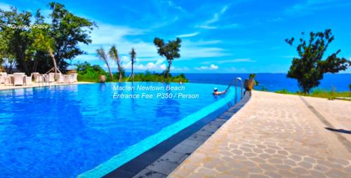 a resort swimming pool with a view of the ocean at Mactan Newtown - 1BR Stunning Ocean View and City View in Mactan