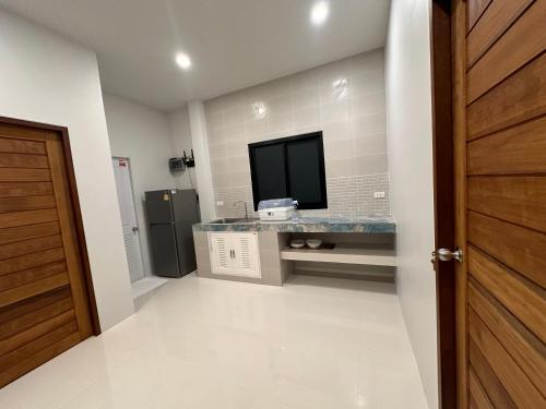 baño con TV y encimera en Cha-emHouse1 Baantai, en Thong Sala
