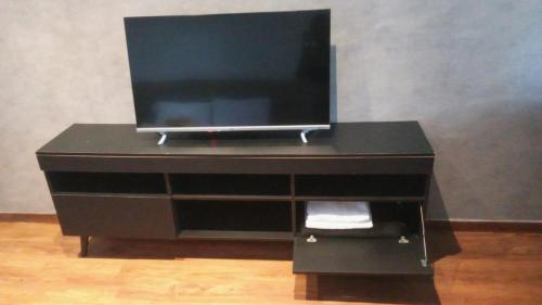 a black dresser with a television on top of it at Bahia Hotel Sol Vitoria Marina Flats in Salvador