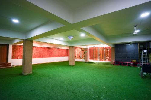 an empty room with a green floor in a building at Sunrise A Boutique Hotel Kondapur in Kondapur