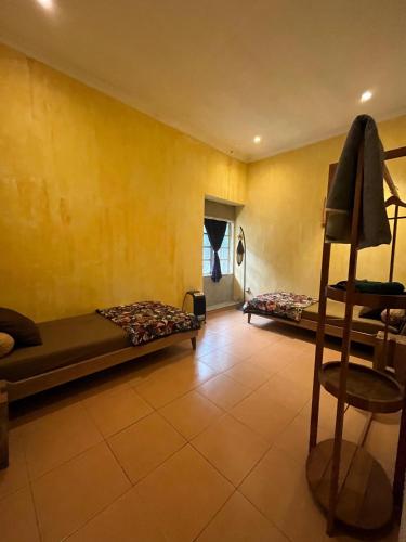 a room with two beds and a chair in it at D'Kastil Jogja in Cepit