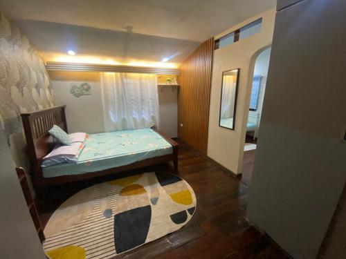 a small bedroom with a bed and a rug at Ranks Homestay in Cagayan de Oro