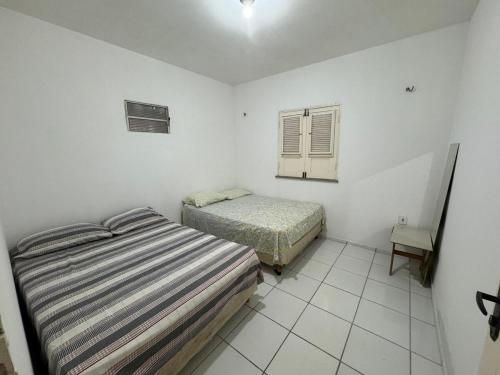 a bedroom with two beds and a window at Casa de praia in Luis Correia
