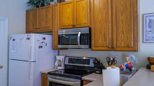 a kitchen with a white refrigerator and a microwave at Heron's Nest in Port Saint Lucie