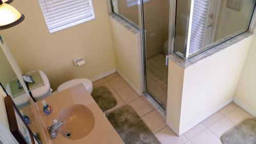 a bathroom with a shower and a sink and a toilet at Heron's Nest in Port Saint Lucie