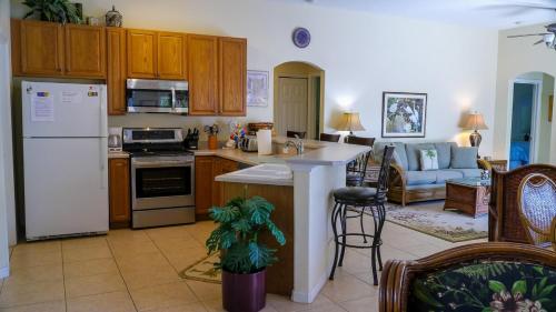 a kitchen and living room with a white refrigerator at Heron's Nest in Port Saint Lucie