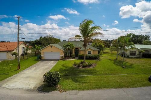 a house with a palm tree in the yard at Heron's Nest in Port Saint Lucie