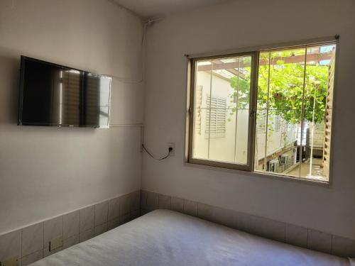 a small room with a bed and a window at HOTEL RESIDENCIAL CAMACHO in Cordoba