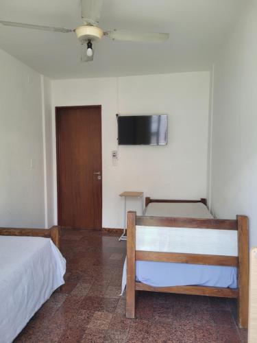a room with two beds and a flat screen tv at HOTEL RESIDENCIAL CAMACHO in Cordoba