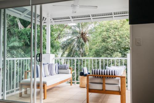 a porch with a couch and chairs on it at Portsea 74 - Live a little in Port Douglas