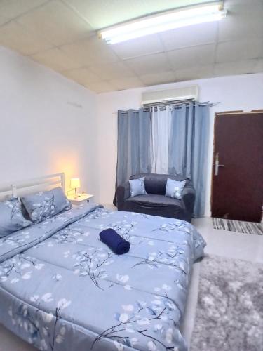 a bedroom with a large bed and a chair at Al Ain Blue in Al Ain