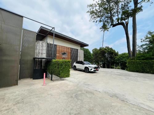 a white car parked in front of a building at Charcoal Panwa Beach Phuket in Ban Tha Khreng