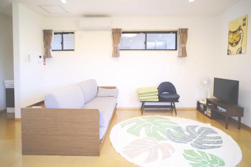 a living room with a couch and a tv at 渡 - Duo Okinawa in Onna