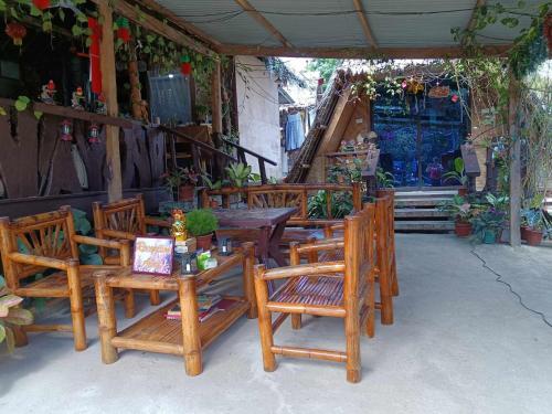 eine Gruppe von Holztischen und -stühlen auf einer Terrasse in der Unterkunft Daisy Food House and Inn in Maria