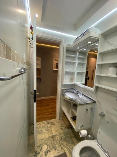 a bathroom with a sink and a toilet and a mirror at Garden Moinhos de Vento in Porto Alegre