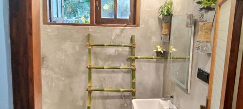 a bathroom with a bamboo towel rack on the wall at Hill Top Heaven in Hikkaduwa