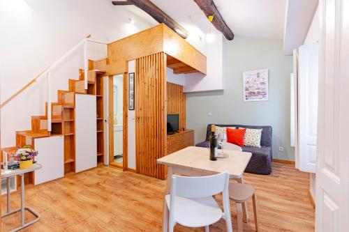 a living room with a table and chairs and a staircase at Antero Quental Residence in Porto