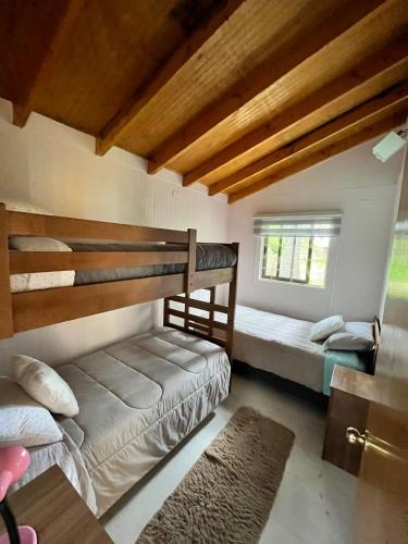 a bedroom with two bunk beds and a window at Cabañas en Valdivia in Valdivia