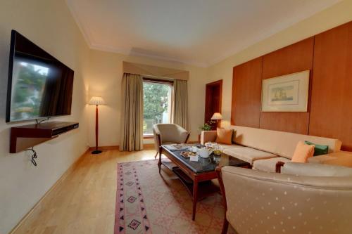 a living room with a couch and a table at The Fern-An Ecotel Hotel, Kochi in Cochin