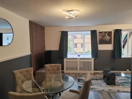 a living room with a glass table and chairs at Domasi Flat in New Cross in London