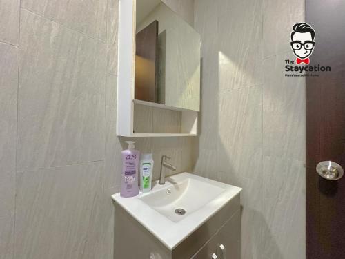 a bathroom with a sink and a mirror at Staycation Homestay 65 Liberty Grove Near Airport in Kuching