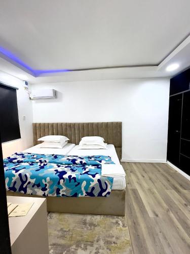 a bedroom with a bed with a blue blanket at DingãBell ApartHotel in Ikeja