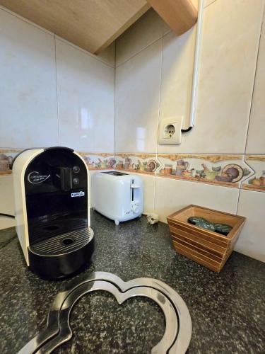 a kitchen with a toaster and a coffee maker on a counter at Casa da Anunciada | Old Town in Setúbal